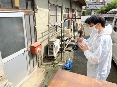 玄関前で拝んでいるスタッフ