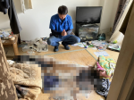 孤独死現場で手を合わせるスタッフ