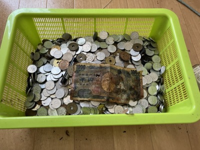 カゴの中に小銭等の現金が大量に入っている画像