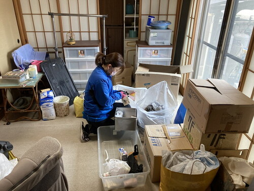 遺品整理時の分別作業を行う女性