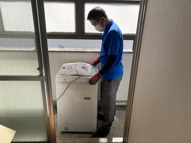 洗濯機を運んでいる様子のスタッフ