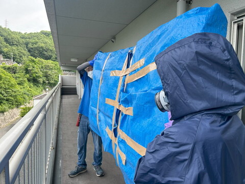 ベッドマットを運んでいる様子のスタッフ