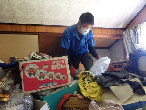 ゴミの上に乗る男性スタッフ