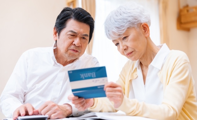 通帳を見る夫婦